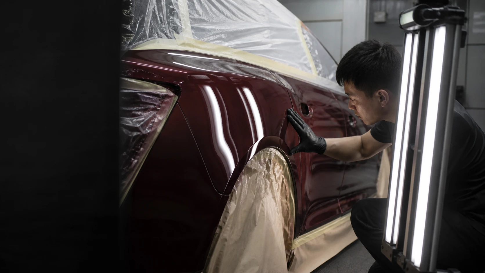 Illustration of a technician checking reflections across a repainted car panel